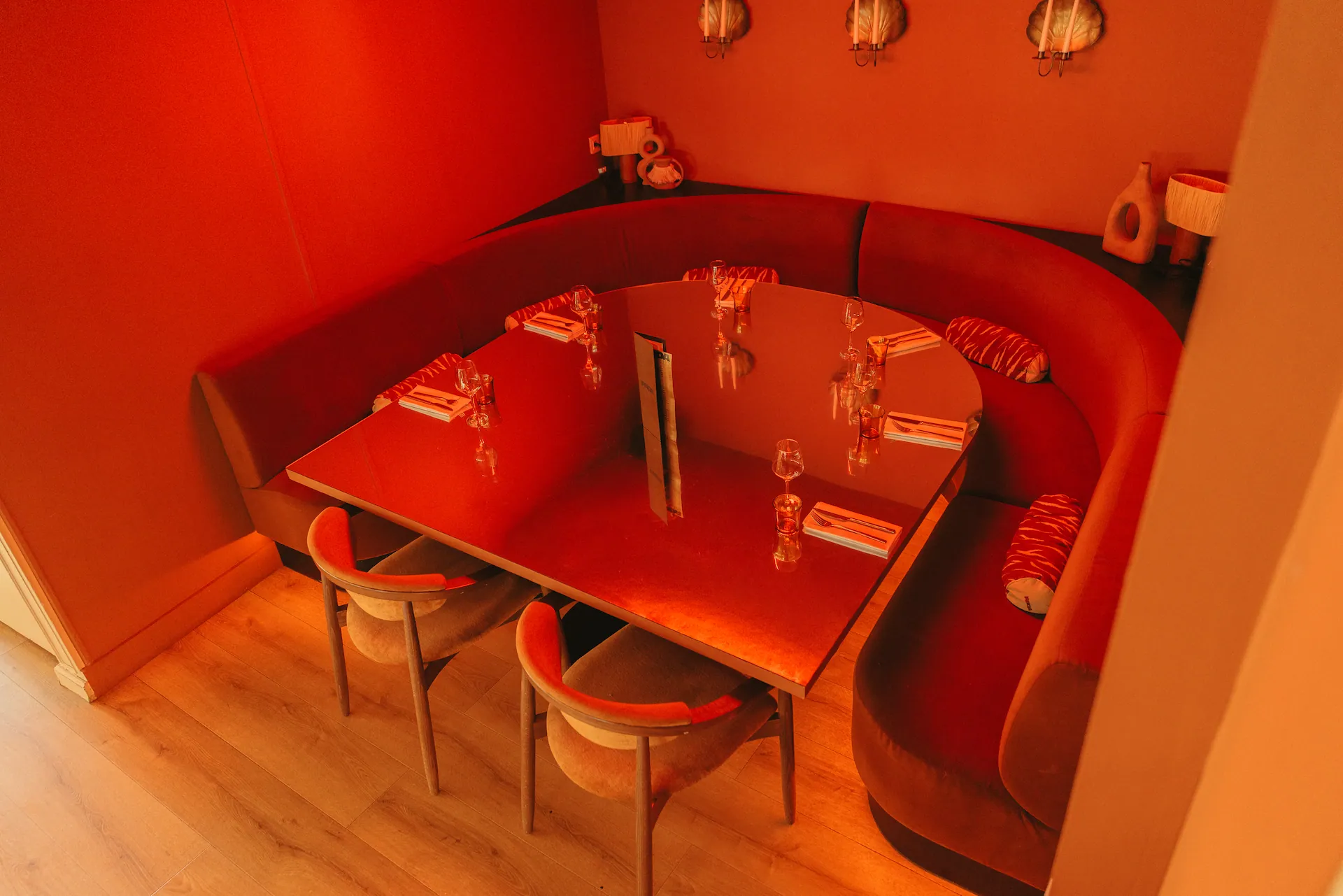 Un recoin à l'écart, une table entourée d'une banquette rouge arrondie